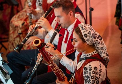 Zbliżenie na artystów orkiestry grających na klarnecie i fletach