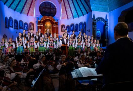 Chór, orkiestra i dyrygent podczas koncertu