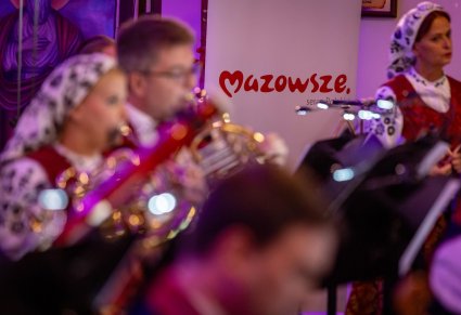 Orkiestra podczas koncertu, w tyłu widoczny roll up "Mazowsze. serce polski"