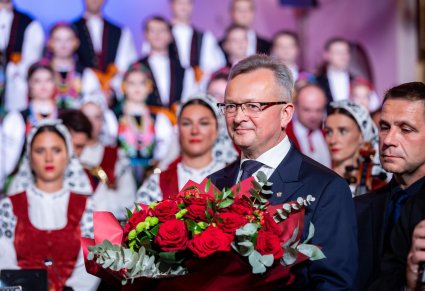 Mężczyzna z kwiatami, w tle orkiestra