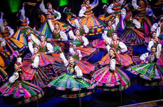  Zbliżenie na tancerki w kostiumach łowickich w trakcie obrotów na scenie