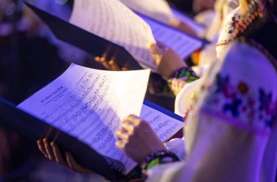  Nuty "Stabat Mater" trzymane przez chórzystkę w kostiumie łowickim