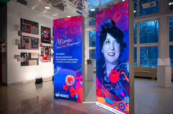  Ścianki LEDowe z grafikami wydarzenia, w tle widoczna wystawa poświęcona Mirze
