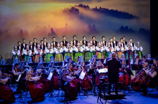  Artyści na scenie w kostiumach łowickich z widoczną orkiestrą