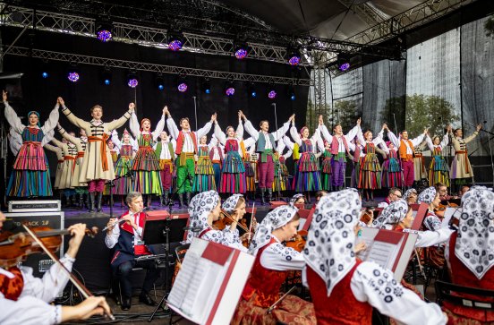  Artyści na scenie w kostiumach opoczyńskich z widoczną orkiestrą