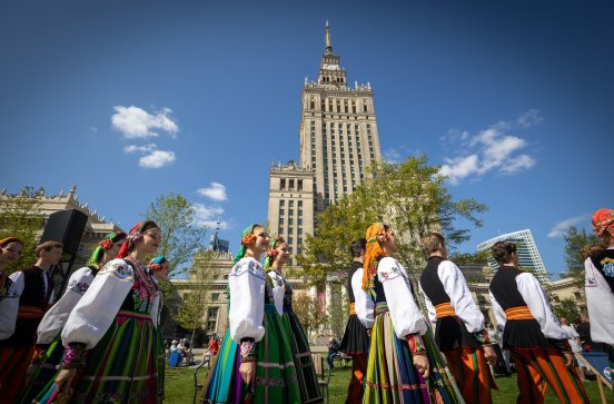  Chór w kostiumach łowickich na tle Pałacu Kultury i Nauki w Warszawie