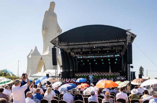  Na scenie Artyści zespołu Mazowsze w kostiumach ludowych, w tle monument Matki Bożej Miłosiernej