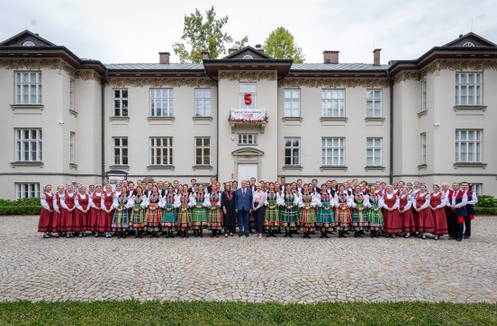  Dyrektor zespołu razem z chórem w kostiumach łowickich i orkiestrą w kostiumach wilanowskich, a także przedstawicielkami Centrum Folkloru Polskiego "Karolin"