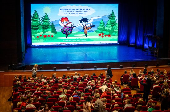  Sala widowiskowa przed koncertem, widoczna widownia i grafika otwierająca koncert na ekranie