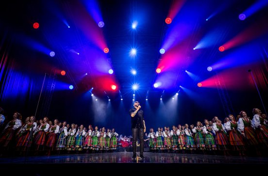  Na scenie Solista zespołu Kombii a w tle Artyści z zespołu "Mazowsze"