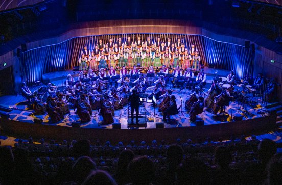  Na scenie w  Cavatina Hall w Bielsku-Białej Artyści chóru w kostiumach łowickich, Orkiestra, widoczna również część publiczności